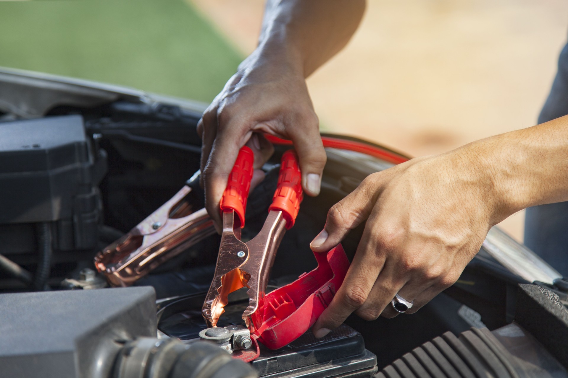 Man using battery jumper cables on a dead battery